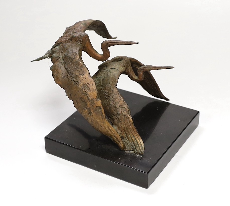 A bronze model of two herons in flight, on slate base 14cm tall